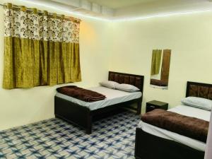 a room with two beds and a window at Tridev Hills in Ujjain