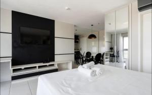 a living room with a tv and a white table at Flat com vista espetacular no centro de Brasília Vision Work and live in Brasília