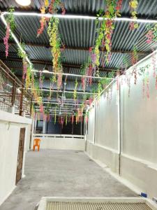 an empty hallway with flowers hanging from the ceiling at Tridev Hills in Ujjain