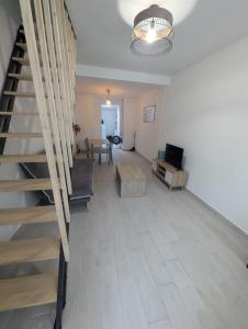 a living room with a staircase and a couch and a table at 2 bedroom house Bourbourg in Bourbourg