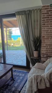 a bedroom with a bed and a sliding glass door at Thalantheia House in Agios Konstantinos