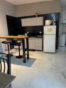 eine Küche mit einem weißen Kühlschrank und einem Tisch in der Unterkunft Herrera in Caucete + 1 Foto