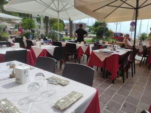 a group of tables with red and white table cloth at Hotel & Restaurant San Marco AB in Toscolano Maderno