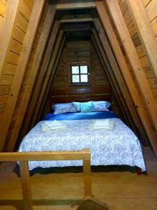 a bed in the attic of a log cabin at Residencial Rodrigues Florianópolis in Florianópolis