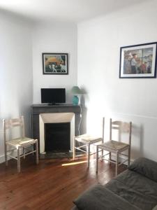 a living room with two chairs and a fireplace at Etchebarne in Saint-Jean-de-Luz