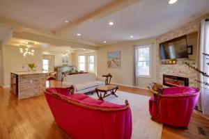 a living room with two red chairs and a fireplace at Walk to Kinnickinnic Ave! Newly Updated Abode in Milwaukee
