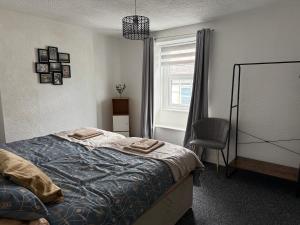 a bedroom with a bed and a chair and a window at 18 Main Street in St Bees +7 photos