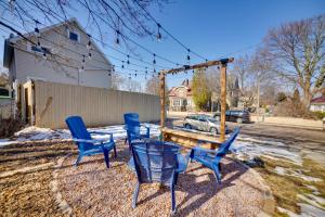 a group of blue chairs and a wooden swing at Walk to Kinnickinnic Ave! Newly Updated Abode in Milwaukee
