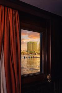 a window with a view of a group of boats in the water at YOU Nile View Hotel in Cairo +16 photos