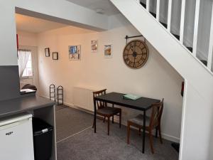 a dining room with a table and a clock on the wall at 18 Main Street in St Bees