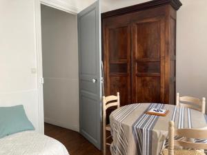 a room with a table and a cabinet and a bed at Etchebarne in Saint-Jean-de-Luz +9 photos
