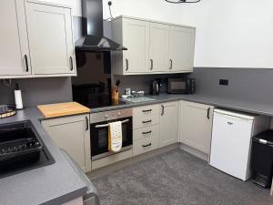 a kitchen with white cabinets and a stove top oven at 18 Main Street in St Bees