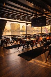 a restaurant with tables and chairs and a view of a city at YOU Nile View Hotel in Cairo