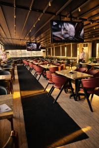 a restaurant with tables and chairs and a large screen at YOU Nile View Hotel in Cairo