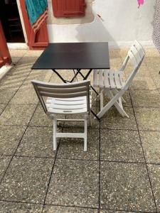 two chairs sitting next to a table and a table at Etchebarne in Saint-Jean-de-Luz
