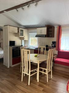 a kitchen and dining room with a table and chairs at camping bonneval in Jaujac