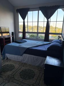 a bedroom with two beds and a large window at El Balcón de Ataco in Concepción de Ataco