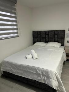 a bedroom with a large bed with two towels on it at Casa Vernazza in Manizales
