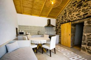 a kitchen and dining room with a table and chairs at Uíma River House in Lobão