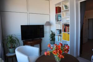 a living room with a vase of flowers on a table at Maison TORTONI in Bastia +4 photos