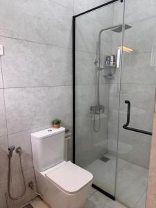 a bathroom with a toilet and a glass shower at Villa Auxesiaa in Wattala