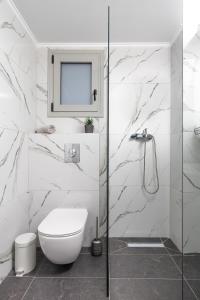 a bathroom with a toilet and a glass shower at Anatoli Urban Apartment with private parking in Xanthi +20 photos