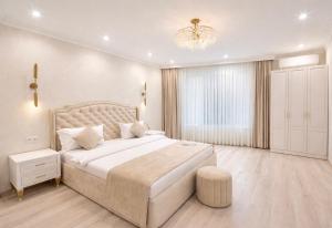 a white bedroom with a large bed and a chandelier at Yerevan In Boutique Hotel in Yerevan