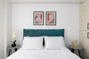 a bedroom with a bed with three pictures on the wall at Anatoli Urban Apartment with private parking in Xanthi