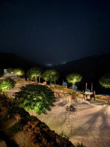 a park with tables and trees at night at Dana Trail Cottages in Dana