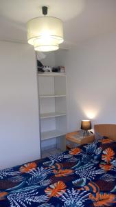 a bedroom with a bed with a blue and orange blanket at Les Clés Nature Apt 44 in Moutiers-sous-Chantemerle