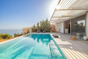 a swimming pool with a view of the ocean at Villa Anatoli in Achlia