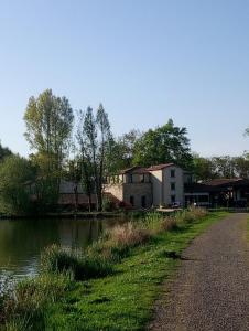 a house next to a river with a building at Les Clés Nature Apt 44 in Moutiers-sous-Chantemerle