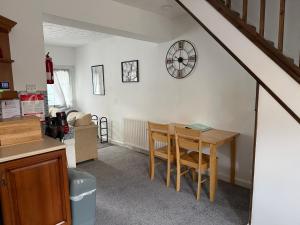 a kitchen with a table and a clock on the wall at 17 Main Street in St Bees