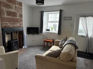 a living room with a couch and a fireplace at 17 Main Street in St Bees