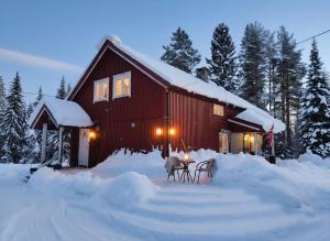 a red barn with a table in the snow at Landgård Feriehus, Trysil sentrum, only a 5 minutes drive in Trysil