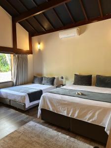 a bedroom with two beds and a window at Gaia Hotelaria in Teresópolis