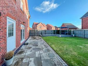 a backyard with a brick building and a yard with a yard at Modern spacious Home in Rhyl in Rhyl