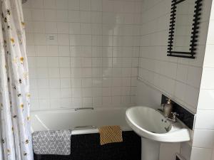 a white bathroom with a sink and a tub and a sink at 16 Main Street in St Bees +4 photos
