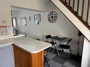 a kitchen with a table and a clock on the wall at 16 Main Street in St Bees