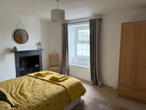a bedroom with a yellow bed and a window at 16 Main Street in St Bees