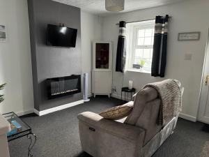 a living room with a couch and a fireplace at 16 Main Street in St Bees