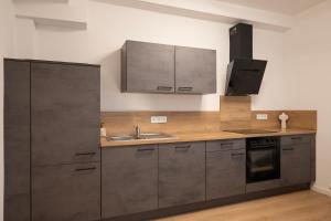 a kitchen with stainless steel cabinets and a sink at ღLiboria Casa Mondo in Murnau am Staffelsee