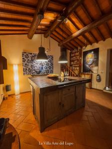a kitchen with an island in the middle of a room at Poolhouse Oasi del Lupo in Subbiano