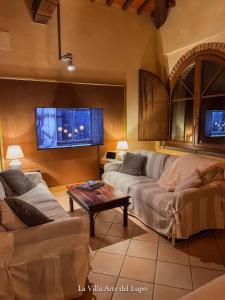 a living room with two couches and a coffee table at Poolhouse Oasi del Lupo in Subbiano