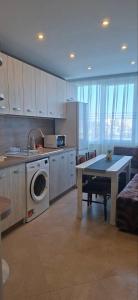 a kitchen with a table and a washing machine at Harmonia in Ruse +16 photos