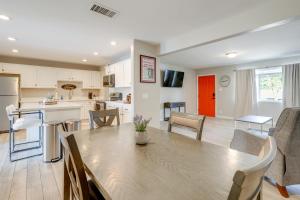 a kitchen and living room with a wooden table in a room at Relax Poolside: Central Group Getaway in Mesa! in Mesa