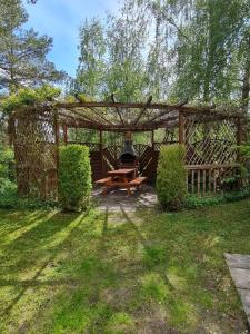 a picnic shelter with a picnic table in a yard at Domek nad jeziorem Anastazewo in Anastazewo