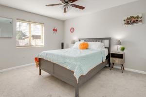 a bedroom with a bed and a ceiling fan at Relax Poolside: Central Group Getaway in Mesa! in Mesa +23 photos
