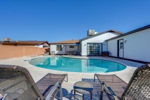 a swimming pool with chairs and a house at Relax Poolside: Central Group Getaway in Mesa! in Mesa