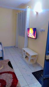 a living room with a tv on a wall at The Great Stay Mtwapa in Mtwapa